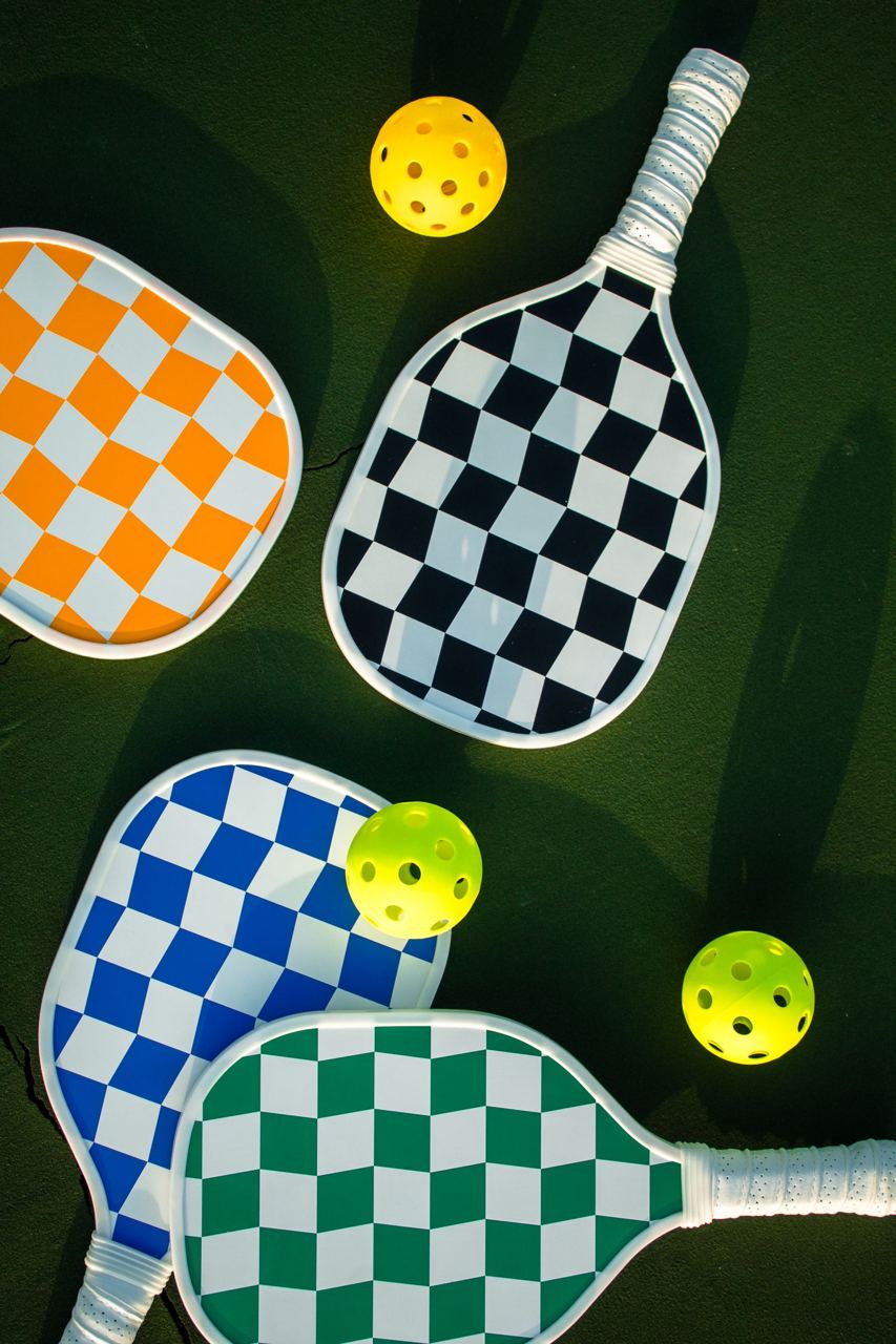 Colorful pickleball paddles and balls, illustrative stock photograph