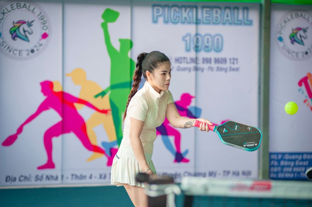 Player holding a pickleball paddle indoors, illustrative photograph unrelated to a DUPR-rated event