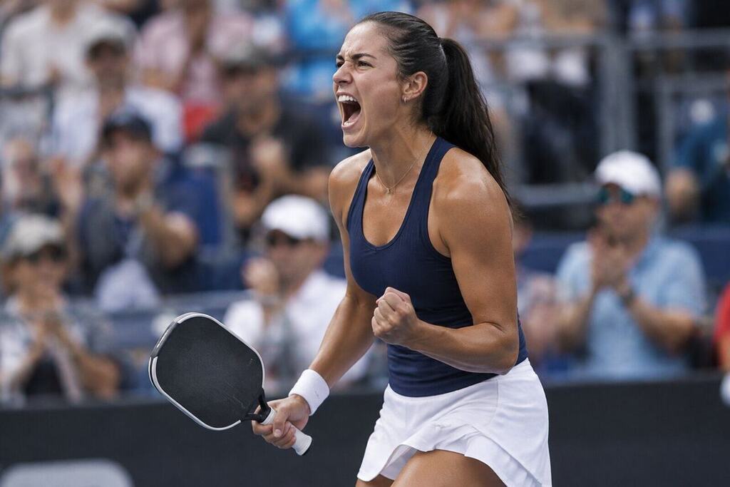 A female pro pickleball player shouting in celebration after winning a match point, fists clenched