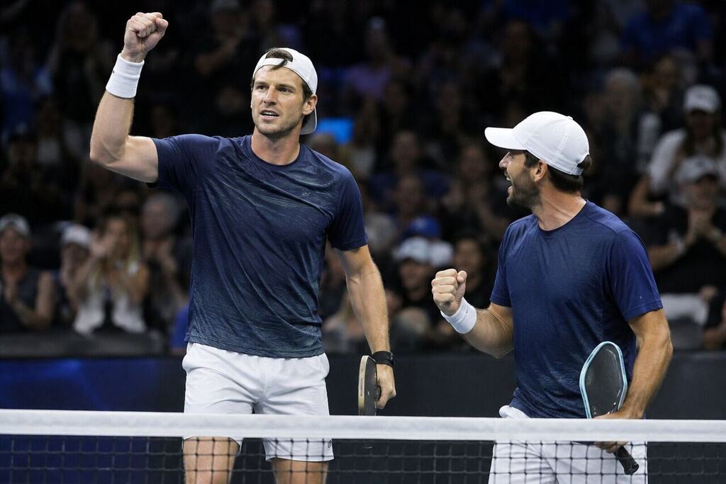 Two male pickleball players celebrating a point at the net during a professional doubles final