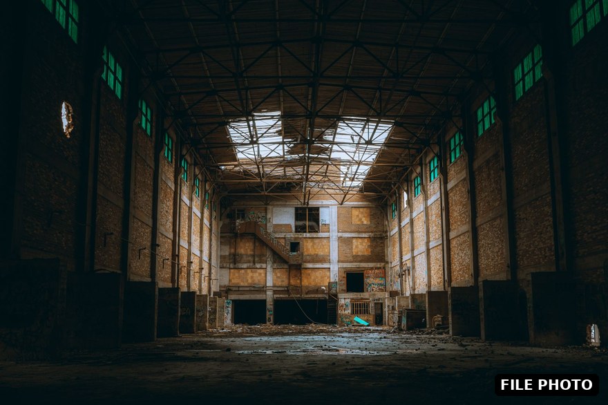 An empty industrial warehouse interior with skylights, the kind of big-box shell a dedicated facility is built inside