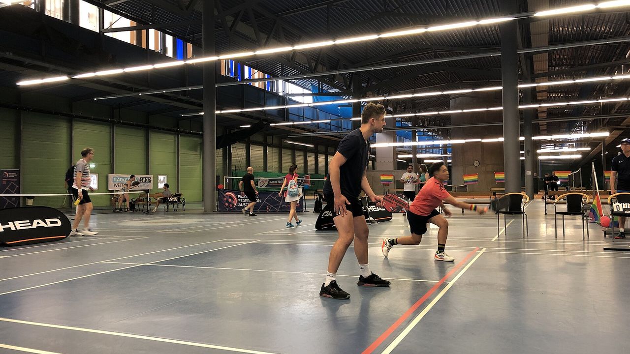 Players moving on an indoor court at a pickleball tournament