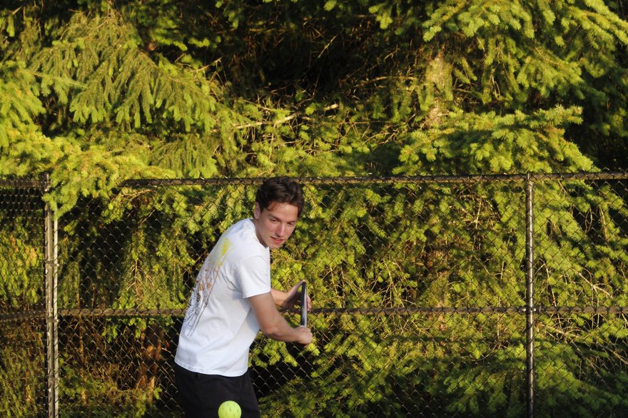 A pickleball player practicing a soft shot at the net on an outdoor court