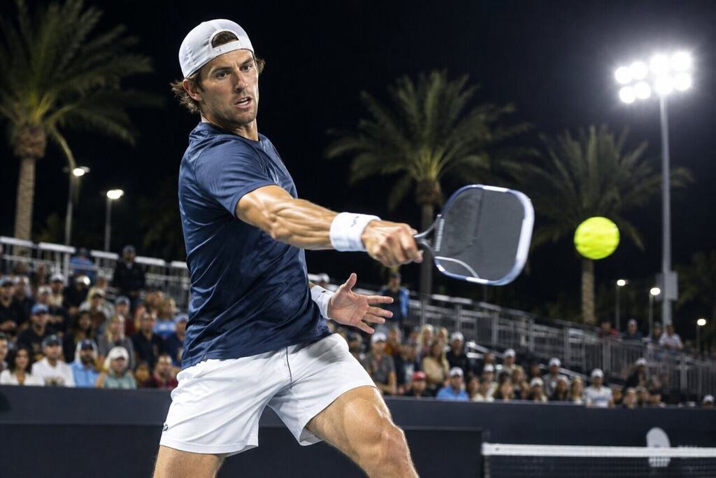 A male pro pickleball player hitting a powerful forehand during a night final under stadium lights in Las Vegas