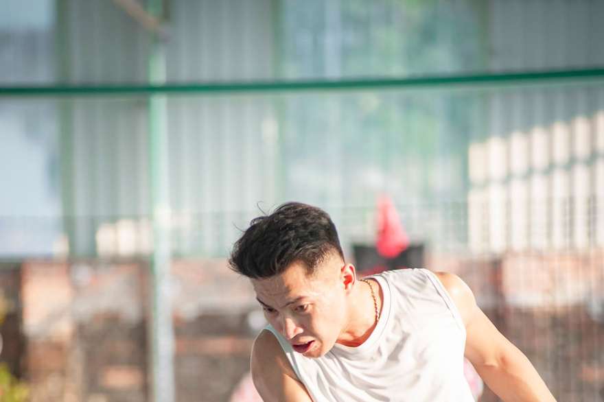 A pickleball player mid-rally on an outdoor court