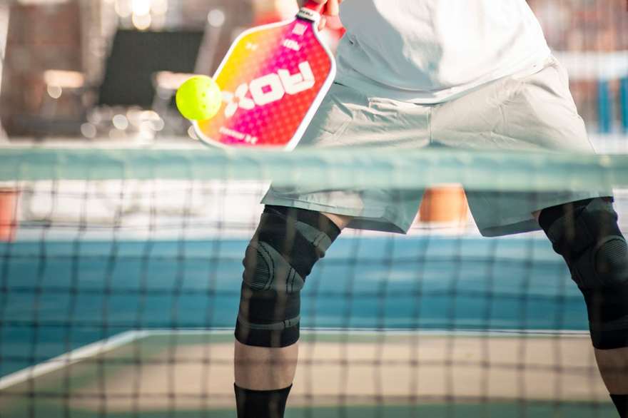 A pickleball player hitting a forehand on court