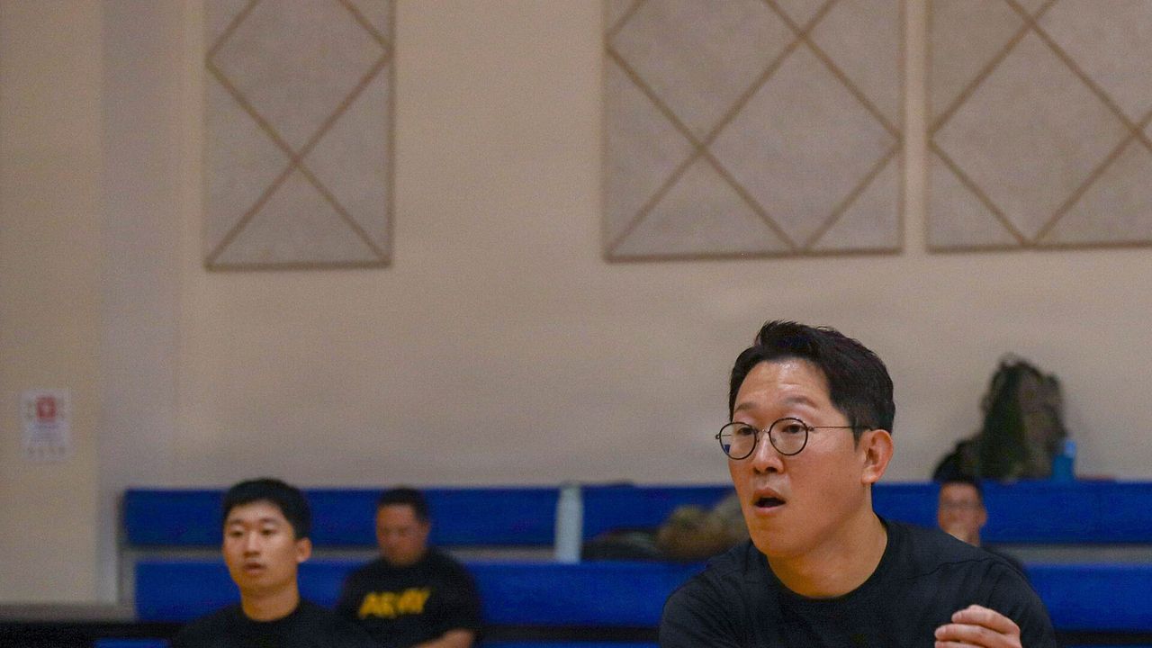 A player in a gym holding a pickleball paddle
