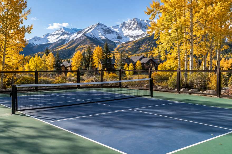 Illustrative image of an outdoor pickleball court in a mountain town in autumn