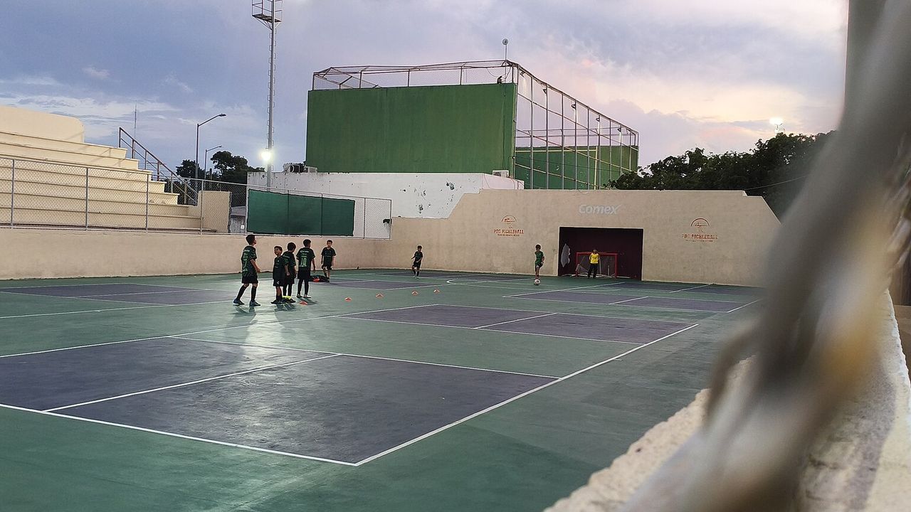 A covered pickleball stadium court with lines and nets