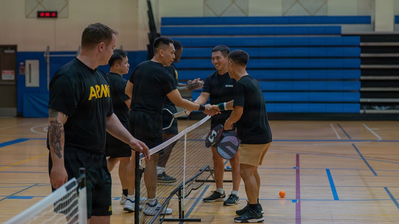 Players in a gym during a pickleball rally