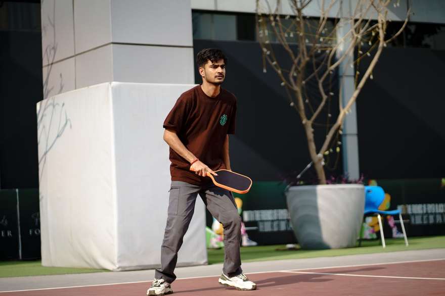A player on an outdoor pickleball court mid-game