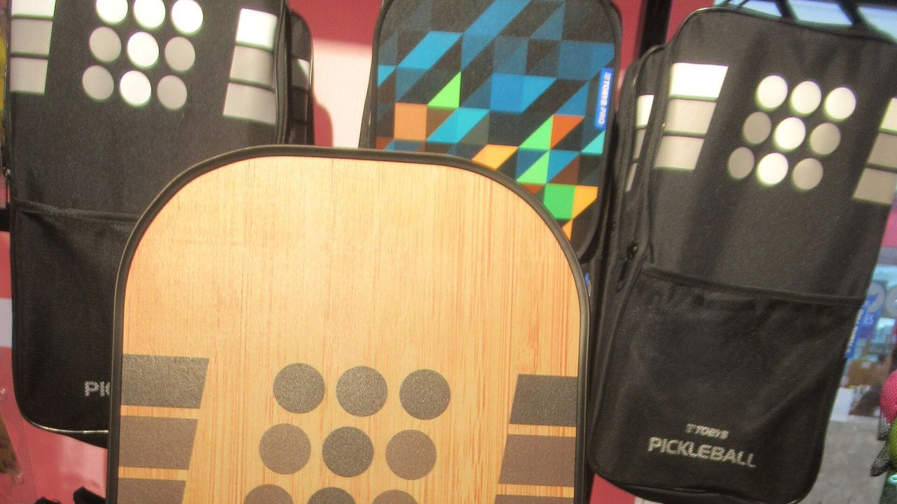 The face of a wooden-colored pickleball paddle with a dotted pattern