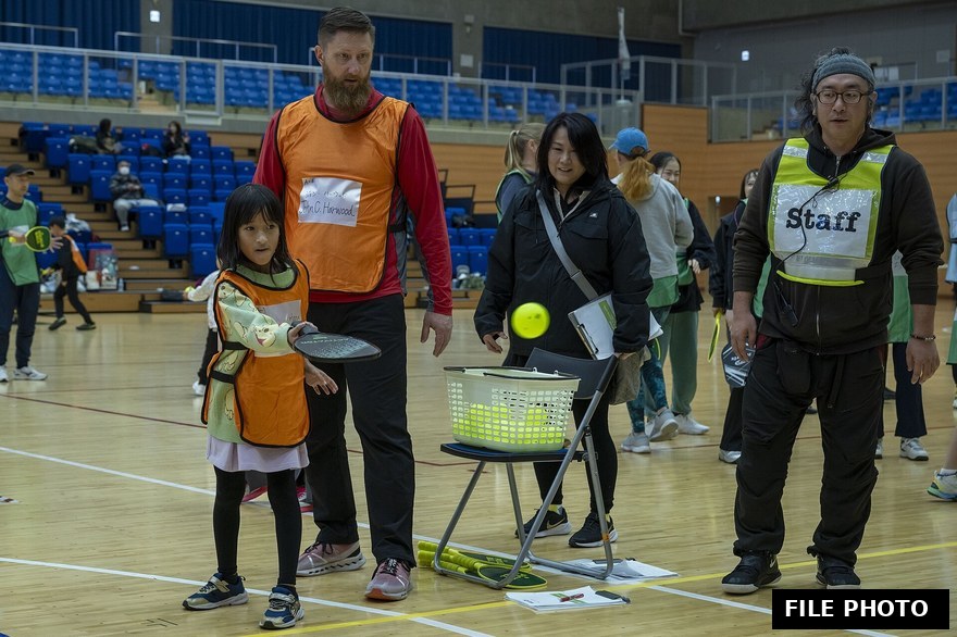 Competitive pickleball rally at a crowded outdoor court