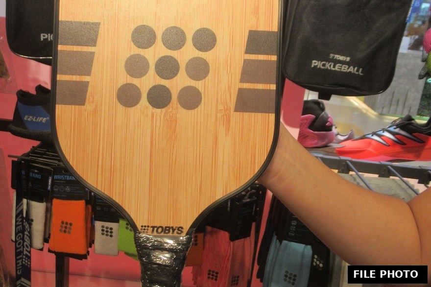 Close-up of pickleball paddles and balls on a court